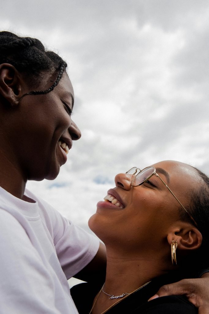 Pareja femenina sonriente mirándose con afecto, imagen de superación de la dependencia emocional – Ana Serrano Psicóloga.