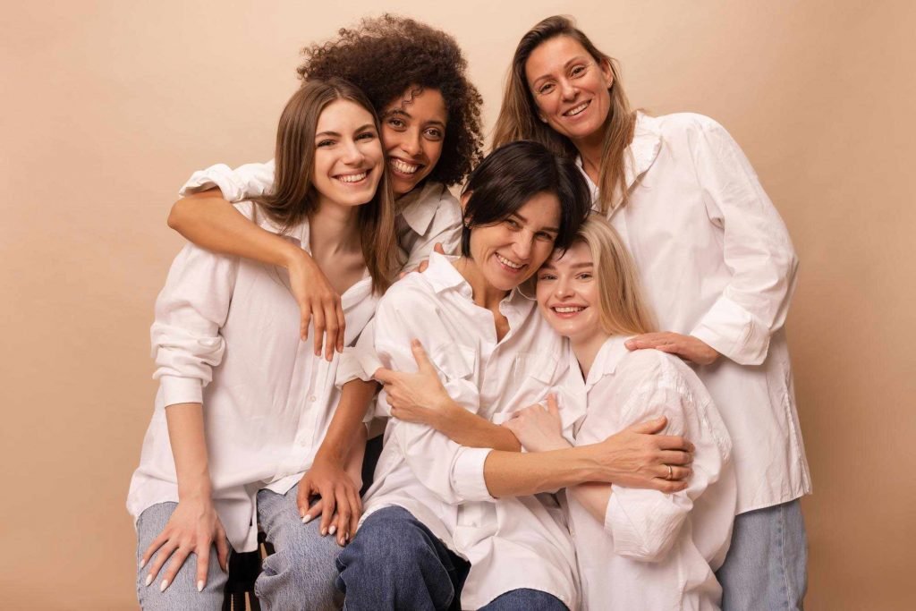 Grupo de mujeres diversas sonriendo y abrazadas. Terapia feminista grupal con Ana Serrano Psicóloga.